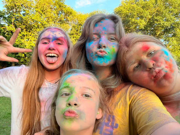 Altenhausen 1- Gruppenbild Eine Gruppe von 3 Mädchen und lehnt sich an eine Betreuer*in, alle haben bunte Gesichter und machen einen Kussmund