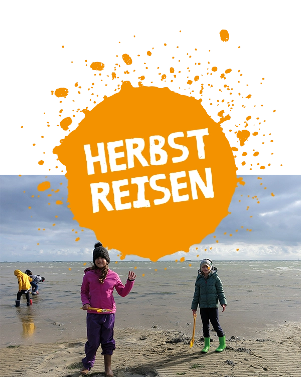 Kinder am Strand, im Watt mit Mützen und Regenjacken und der Beschriftung Herbstreisen